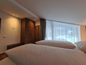 2 letti in una camera d'albergo con finestra di Chalet Gravina a Ortisei