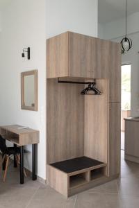 a wooden cabinet in a kitchen with a table at Loggos Apartments in Lóngos