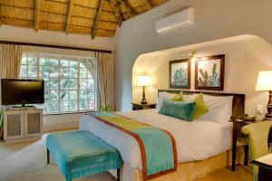 a bedroom with a large bed and a television at Mount Grace Hotel & Spa in Magaliesburg