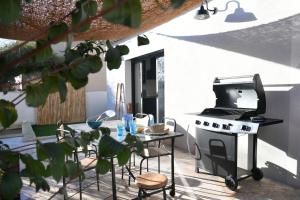 une cuisine avec une cuisinière et une table avec des chaises dans l'établissement La maison de Flore, à Pernes-les-Fontaines