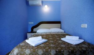 una camera blu con un letto e asciugamani di Lilia guesthouse a Sighnaghi