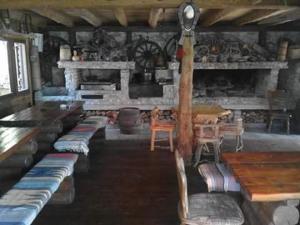 a dining room with tables and chairs and a fireplace at Apartmani Dada Kanjon Grmuša in Bihać