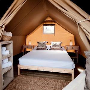 锡切斯HolaCamp Sitges Garrofer的帐篷内一间卧室,配有一张床