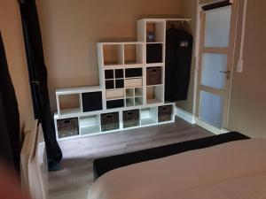 a room with white shelves and a bed in it at Appartement vue panoramique, sur les hauteurs de Lons in Lons-le-Saunier