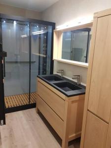 a bathroom with a sink and a glass shower at Appartement vue panoramique, sur les hauteurs de Lons in Lons-le-Saunier