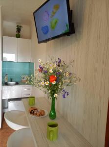 un jarrón de flores sobre una mesa en una cocina en Afrodita, en Štúrovo