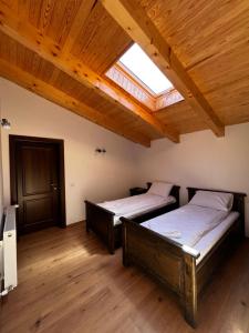 two beds in a room with a skylight at Cabana Mullerhaus in Tău Bistra