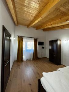 a bedroom with wooden ceilings and a wooden floor at Cabana Mullerhaus in Tău Bistra