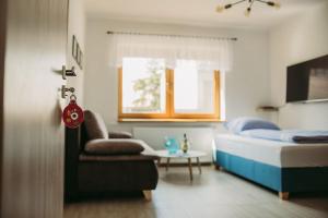 1 dormitorio con 1 cama, 1 silla y 1 mesa en Apartmán U Drába: ubytování na Slovácku v Miloticích u Kyjova, en Milotice