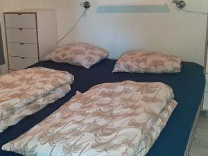 2 camas individuales en una habitación en Holiday home lyngdal V, en Lyngdal