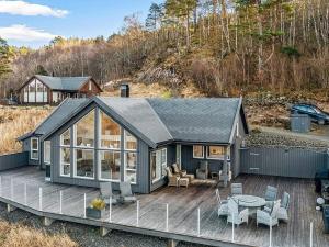 a house with a deck with a table and chairs at 8 person holiday home in lyngdal-By Traum in Lyngdal