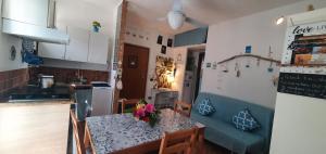 a kitchen and dining room with a table with flowers on it at Madò Apartments Egnazia in Bari +32 photos