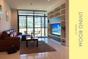 a living room with a couch and a television at Tranquil Condo close to Beach in Kamala Beach