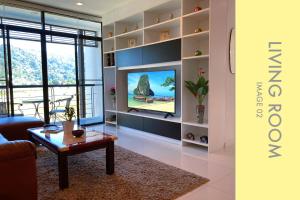 a living room with a tv and a table at Tranquil Condo close to Beach in Kamala Beach