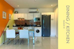 a kitchen with a table and chairs and a refrigerator at Tranquil Condo close to Beach in Kamala Beach
