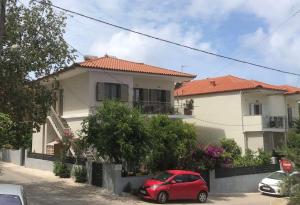a red car parked in front of a house at Cosy studio 1 in Stoupa in Stoupa