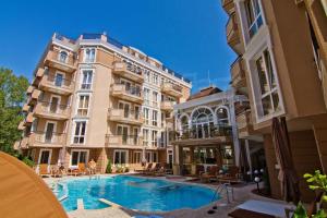 a hotel with a swimming pool in front of two buildings at Menada Apartments in Dawn Park Delux in Sunny Beach