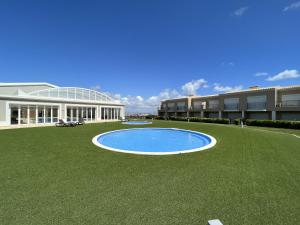 een groot gebouw met een zwembad in het midden van een gazon bij Fairway 3 Appartement - Boavista Golf & Spa Resort in Lagos