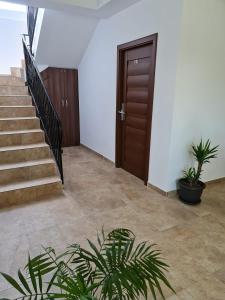 a hallway with stairs and a door and plants at Pensiunea Lotus Corbu in Corbu