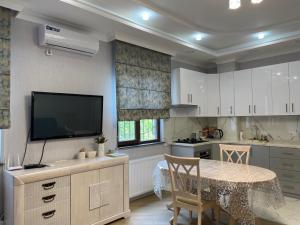 uma cozinha com uma mesa e uma televisão na parede em City Centre Apartment em Kutaisi