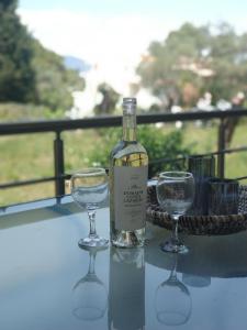 a bottle of wine and two glasses on a table at Coritos apartments Corfu in Kontokali