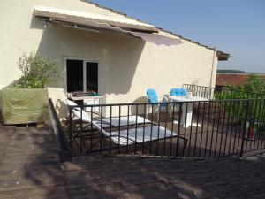 une terrasse avec des chaises et une table en face d'une maison dans l'établissement les Quatre Vents, à Bragny-sur-Saône