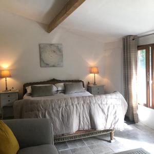 1 dormitorio con 1 cama, 2 lámparas y sofá en Le Petit Appartement `a Cariad La Rebeuse, en Corgnac-sur-lʼIsle
