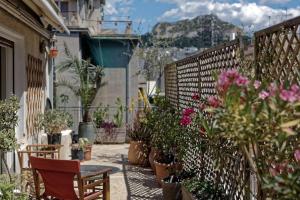 a patio with potted plants and a table and chairs at Athens noir: 1920s vibe on the East Mediterranean in Athens