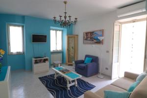 ein blaues Wohnzimmer mit einem Sofa und einem Tisch in der Unterkunft Da Stea guest house in Coreglia Ligure