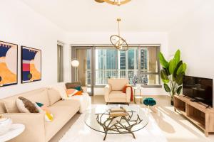 Una sala de estar con un sofá y un televisor. en Prime Retreats - 29 Emaar Boulevard Downtown Dubai, en Dubái