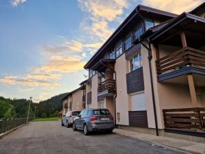 ein paar Autos, die vor einem Gebäude geparkt sind in der Unterkunft LAKI apartman in Zaovine