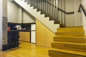 a staircase in a room with a kitchen and a stair case at Super OYO 91328 Fiducia Capsule Hotel in Jakarta