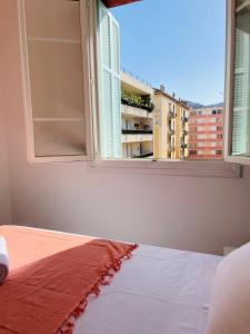 - une chambre avec un lit et une fenêtre ouverte dans l'établissement Appartement Bonaparte centre ville d'Ajaccio, à Ajaccio