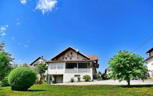 ein großes weißes Haus mit braunem Dach in der Unterkunft House Bićanić in Selište Drežničko