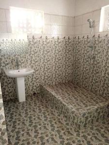 y baño con lavabo, ducha y bañera. en TAMATAVE Chez Bien Aimée, en Toamasina