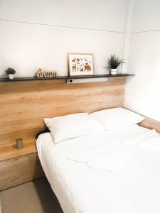 Schlafzimmer mit einem weißen Bett mit einem Kopfteil aus Holz in der Unterkunft Starlight mobile house by Kolpa river in Gradac