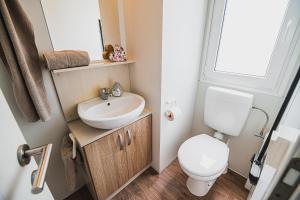 La petite salle de bains est pourvue de toilettes et d'un lavabo. dans l'établissement Lake View Mobile Homes with Thermal Riviera Tickets in Terme Čatež, à Čatež ob Savi