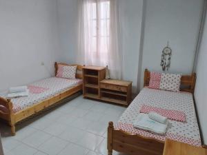 Un dormitorio con dos camas y una cómoda. en Kamari Beach guest house, en Keramídhion