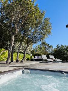 a swimming pool with chairs and trees in the background at F2 avec jacuzzi, pétanque, à 3 min mer, dans grande propriété in Porticcio