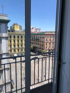 een raam met uitzicht op een stadsstraat bij The Station Napoli in Napels