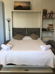 een slaapkamer met een groot bed en 2 handdoeken bij The Station Napoli in Napels