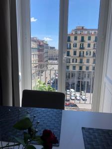 een kamer met een tafel en uitzicht op de stad bij The Station Napoli in Napels