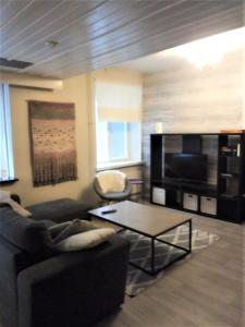 Una sala de estar con un sofá y una mesa de café. en Jokihelmi-apartment, en Kannus