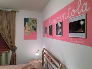 Un dormitorio con una pared rosa y una cama en B&B Margherita Le Fiabe, en SantʼAgata Feltria