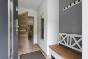 a hallway with a wooden bench and a mirror at APARTAMENT8 Wellness Sauna View 5os in Szczyrk