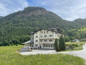 a large white house in front of a mountain at Apart Inntalerhof in Tösens