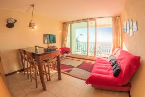 a living room with a table and a red chair at Oceana Suites Bahia Pelicanos in Puchuncaví
