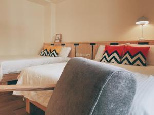 a hotel room with two beds and a couch at Wanna Travel B&B in Taitung City