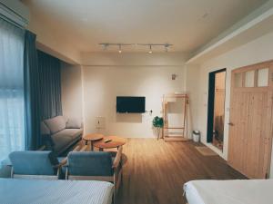 台東市的住宿－想旅行民宿，带沙发、桌子和电视的客房