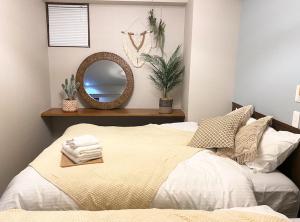 a bedroom with a bed with a mirror on the wall at TOMMY CONDOMINIUM WAKASA 401 in Naha